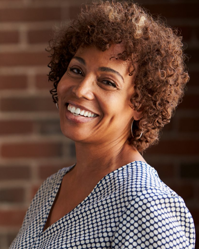 Smiling middle-age woman with short, curly hair