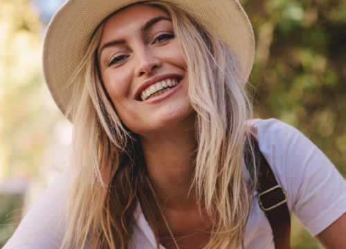Smiling blonde woman wearing a sun hat
